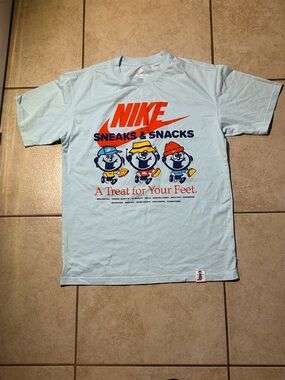 Nike Light Blue 'Sneaks & Snacks' Graphic Tee with Orange Logo